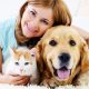A happy pet owner with cat and dog
